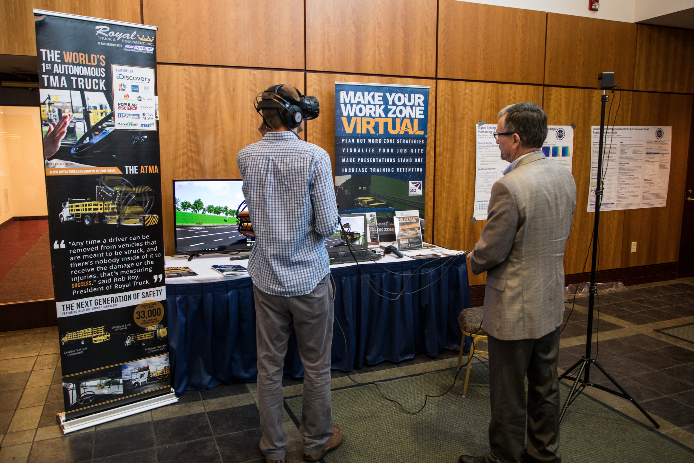 Summit attendee wears virtual reality goggles at an exhibit by Royal Truck & Equipment Inc.