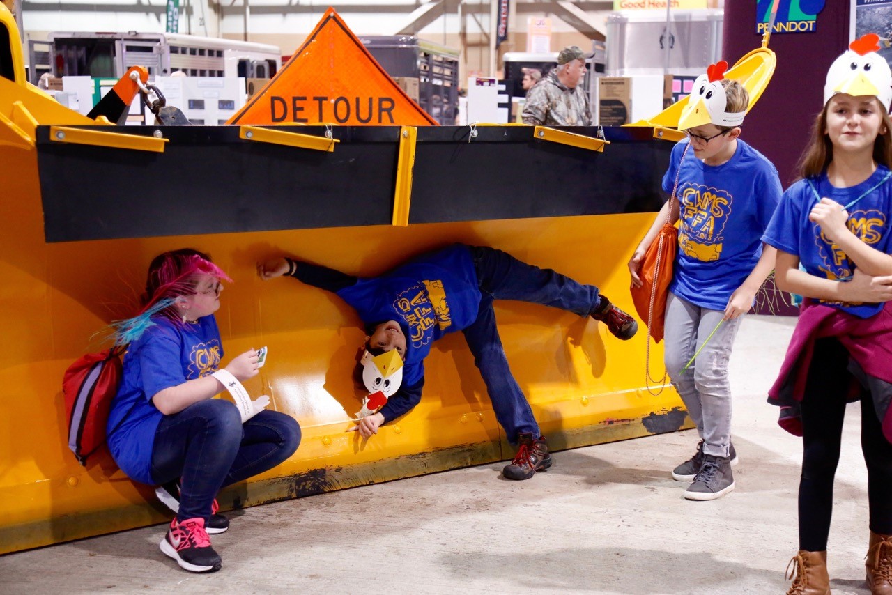 children posing with penndot snow plow at farm show