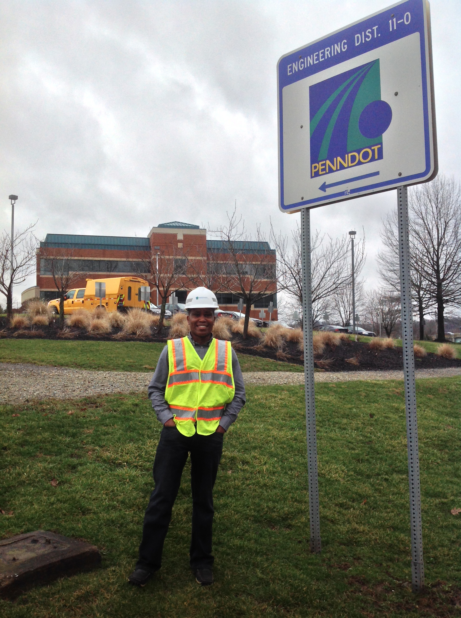 philip mutunga in construction safety gear with penndot building and sign in the background