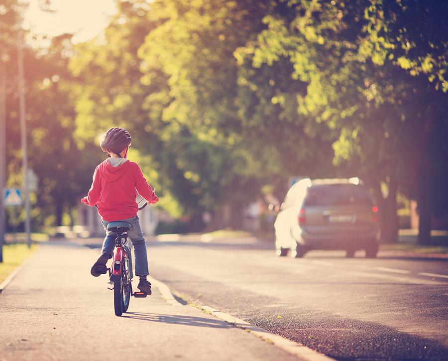 Child riding bicycle on sidewalk