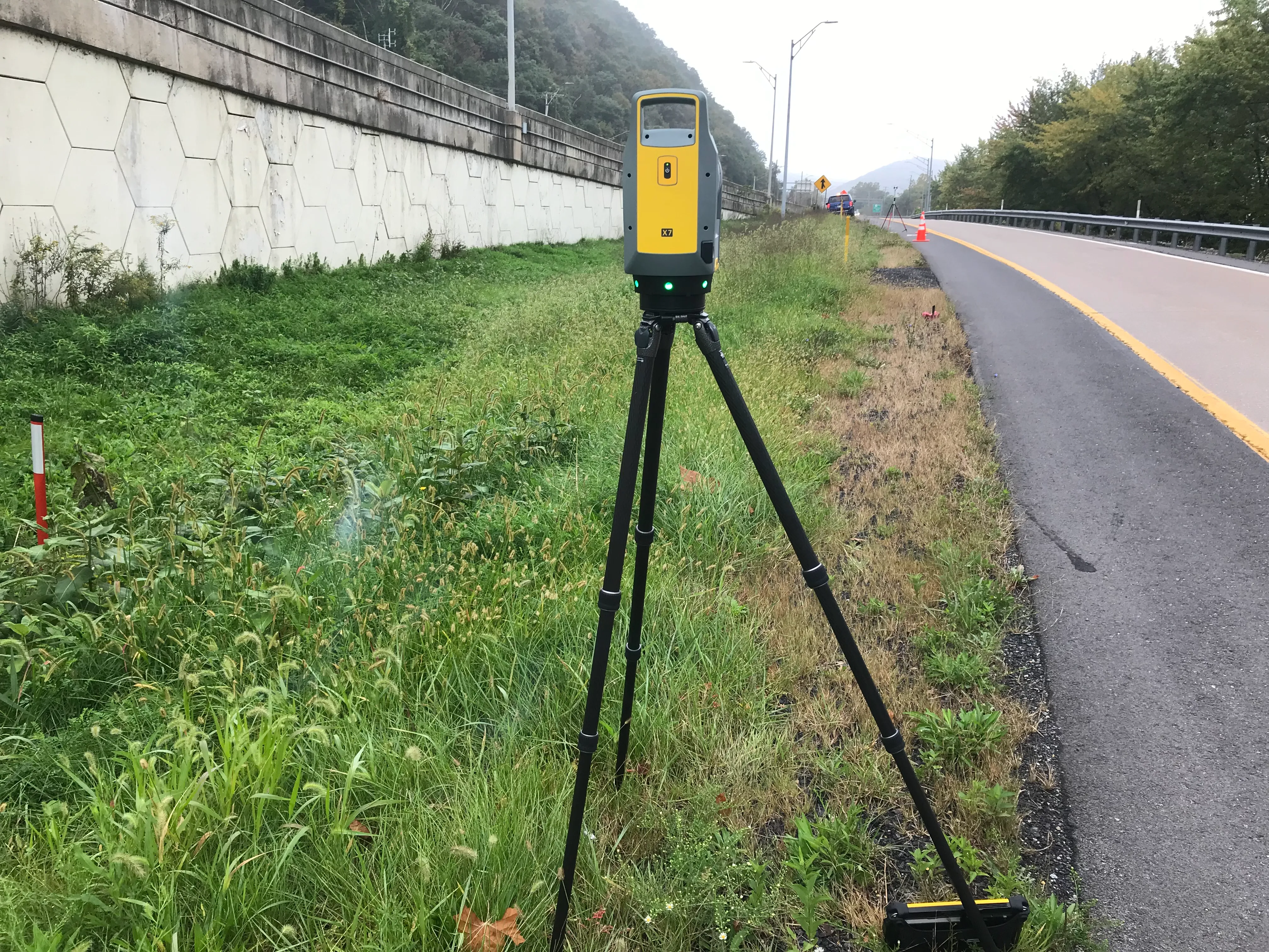 An image of a lightweight three-dimensional laser scanner sitting along an on-ramp.
