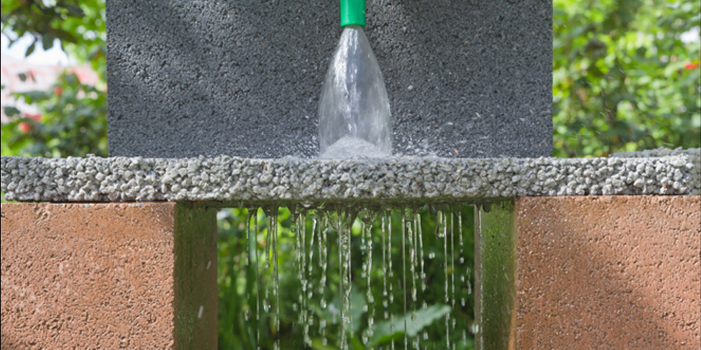 Water passes through porous concrete showing how the pervious pavement innovation can help reduce surface runoff and recharge groundwater supplies.