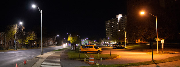 Urban street with bright, white LED light compared to traditional yellow lighting.