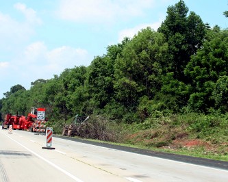 vegetation maintenance work being performed on side of the highway.