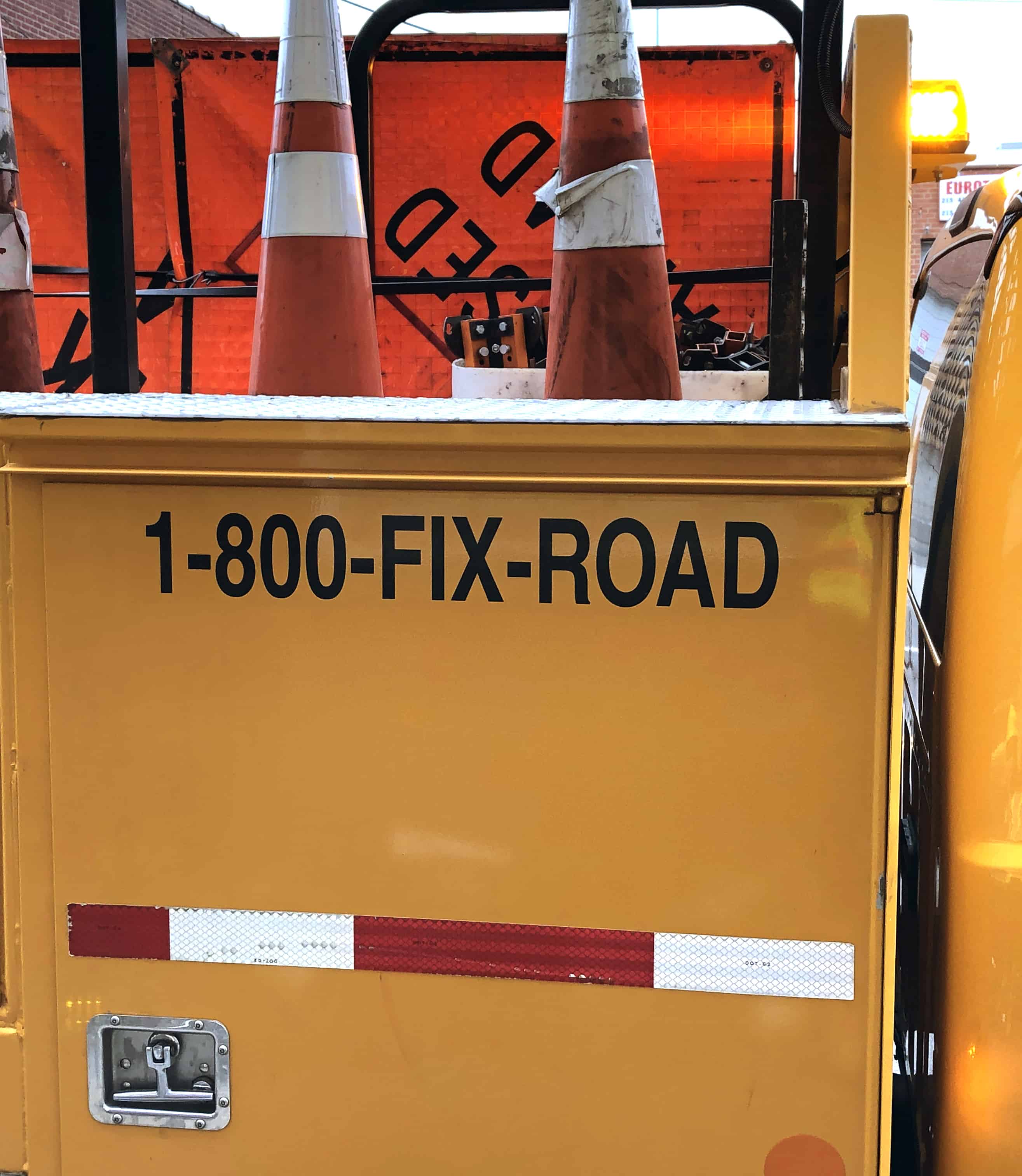 The side of a yellow PennDOT truck with the words 1-800-FIX-ROAD.
